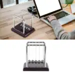 Pendulette Newton en métal avec base en bois foncé, utilisée pour démonstrations scientifiques ou comme décoration de bureau.