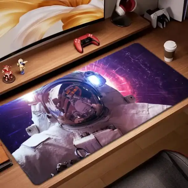 Panneau de bureau avec tapis de souris représentant un astronaute dans l'espace, entouré de figurines et d'objets liés à la science et à la technologie.