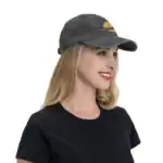 Casquette grise avec motif planétaire, style décontracté, portée par une femme souriante, idéale pour les amateurs de science et d'astronomie.