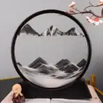 Objet décoratif en forme de cercle avec montagnes et cerisier en fleurs.
