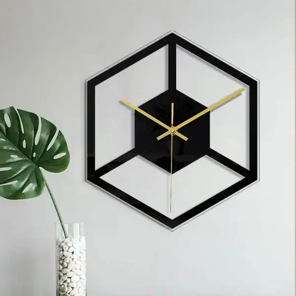 Horloge murale design en forme de cube avec cadre noir et aiguilles dorées, idéale pour une décoration contemporaine.