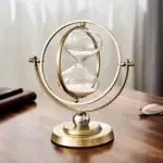 Sablier scientifique décoratif en métal doré avec deux ampoules de verre, symbole du temps et de la science, idéal pour la décoration de bureau ou d'étagère.