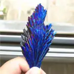 Cristal d'azur brillant avec des reflets iridescents, présenté dans une main pour une décoration scientifique unique.