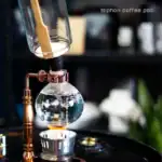 Bocal à café siphon en verre avec systÚme en cuivre, parfait pour une décoration de style scientifique ou pour préparer un café siphon à la maison.
