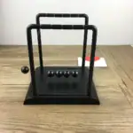 Pendulet Newton en bois et métal, objet de décoration scientifique pour bureau ou intérieur.