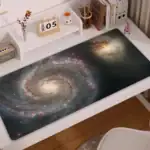 Panneau de bureau avec impression de galaxie, représentant une spirale de l'univers avec des étoiles et des nébuleuses.