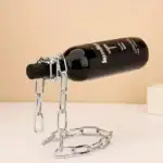 Bouteille de laboratoire noire suspendue par une chaîne en métal, utilisée comme décoration scientifique ou objet de collection.