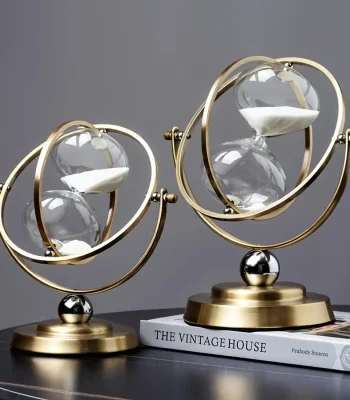 Horloge décorative en forme de sablier avec sphères en verre et structure en métal doré, inspirée du style astronomique, idéale pour la décoration intérieure.