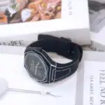 Montre scientifique noire avec cadran analogique et design technique.