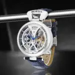Montre mécanique sophistiquée avec mouvement visible, cadran complexe et bracelet en cuir bleu, alliant design scientifique et style moderne.