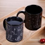 Deux mugs noirs avec motifs d'astres, constellations et signes du zodiaque, parfaits pour les amateurs d'astronomie et de décoration scientifique.