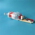 Robot éducatif fabriqué à partir d'une bouteille en plastique recyclée, avec un moteur, une roue en forme de lapin rouge, et une plateforme en bois, illustrant la créativité et le recyclage.
