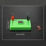 Puce de démonstration de circuit électrique avec fils, aimants et base en plastique vert, utilisée pour des expériences scientifiques éducatives.