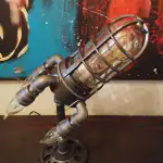 Pistolet décoratif steampunk en métal avec éléments en verre et tuyaux en cuivre, inspiré de la science-fiction et de l'esthétique industrielle. Parfait pour la décoration intérieure ou comme pièce de.