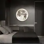Lampe murale en forme de pleine lune illuminant une chambre moderne avec un mur gris foncé, créant une ambiance apaisante et mystérieuse.