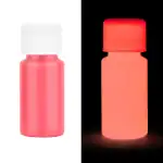 Bouteille de peinture phosphorescente rose visible en lumière normale et sous lumière UV, illustrant la différence d'apparence dans l'obscurité.