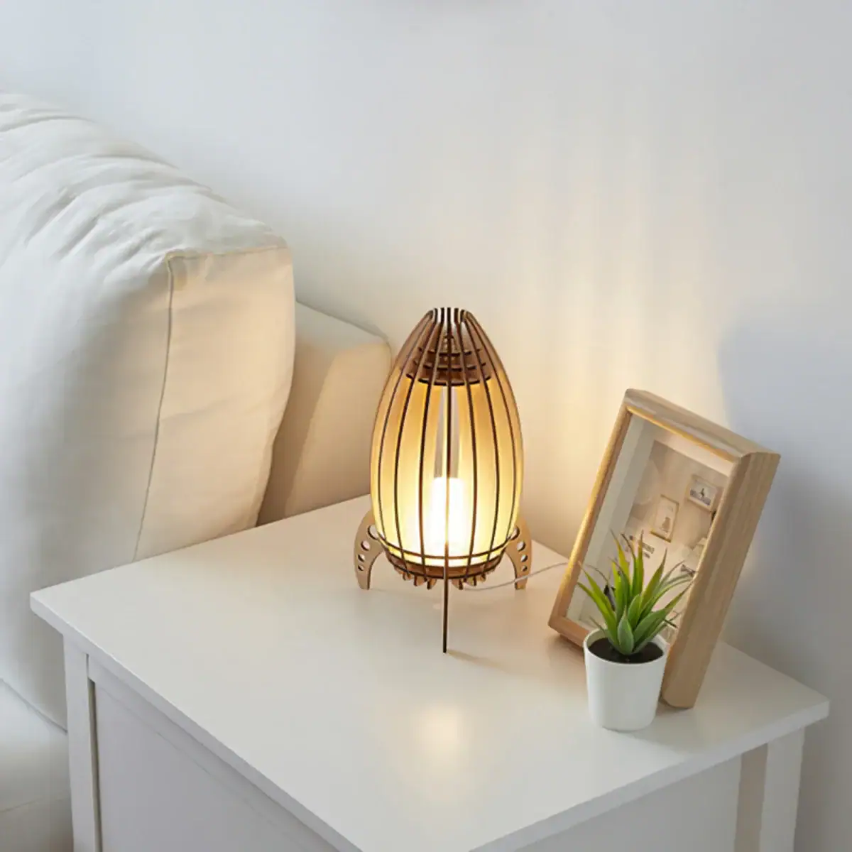 Lampe de table en bois et papier japonais, éclairant doucement un coin de chambre avec une ambiance chaleureuse et naturelle.