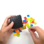 Puce LEGO scientifique avec boîte noire et pièces colorées pour expériences éducatives et activités de science pour enfants.
