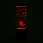 Bouteille de lave luminescente rouge dans l'obscurité, avec des bulles de gaz visibles à l'intérieur, créant un effet visuel captivant.