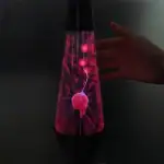 Lampe de plasma colorée avec décharges électriques visibles à l'intérieur, créant un effet lumineux dynamique.