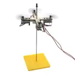 Pupitre d'expérience scientifique avec support en bois, composants électroniques et filaments pour expériences éducatives en physique et sciences.