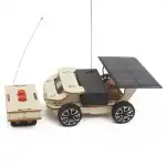 Robot solaire éducatif avec télécommande, panneau solaire, roues en plastique, composants électroniques visibles, conçu pour l'apprentissage de la robotique et de l'énergie solaire.