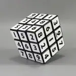 Cube numérique à 3x3 avec chiffres noirs sur fond blanc, utilisé comme objet décoratif ou éducatif, illustrant la science et la logique.