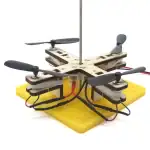 Drone éducatif avec hélices, structure en bois et base en mousse jaune, conçu pour l'apprentissage de la robotique et de la mécanique. Parfait pour les projets scientifiques et éducatifs.