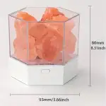 Pierre de sel rose dans un récipient en verre avec base blanche, vue de face.