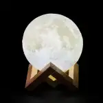 Lampe lune 3D réaliste sur support en bois, éclairage doux, décoration d'intérieur inspirée de l'astronomie, idéale pour une ambiance chaleureuse et cosmique.