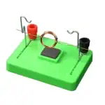 Puce de démonstration d'induction électromagnétique avec bobine de cuivre, aimants et base en plastique vert, utilisée pour illustrer le principe de l'induction électromagnétique en physique.