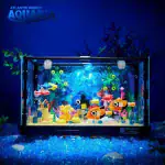 Vitrine d'aquarium marin coloré avec des poissons, des plantes et des éléments décoratifs, idéale pour une décoration scientifique ou éducative.