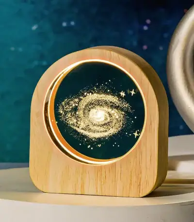 Lampe décorative en forme de galaxie avec lumière LED, idéale pour une décoration scientifique ou cosmique dans une chambre ou un bureau.