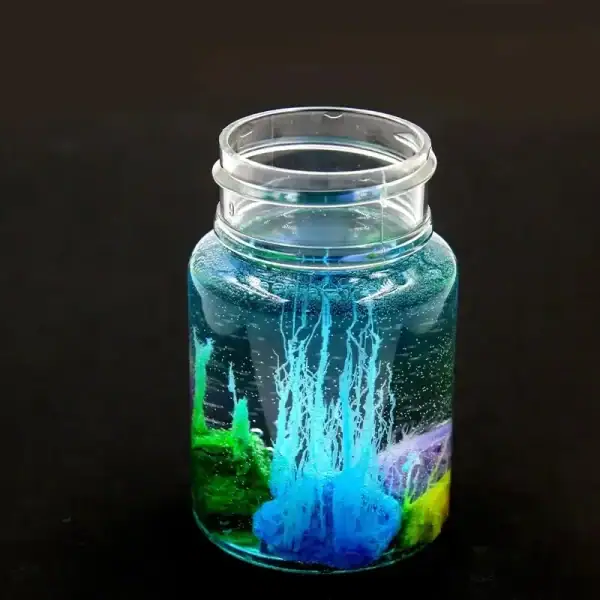 Vase en verre contenant une expérience scientifique avec des liquides colorés et des bulles, illustrant un phénomène chimique ou physique captivant.