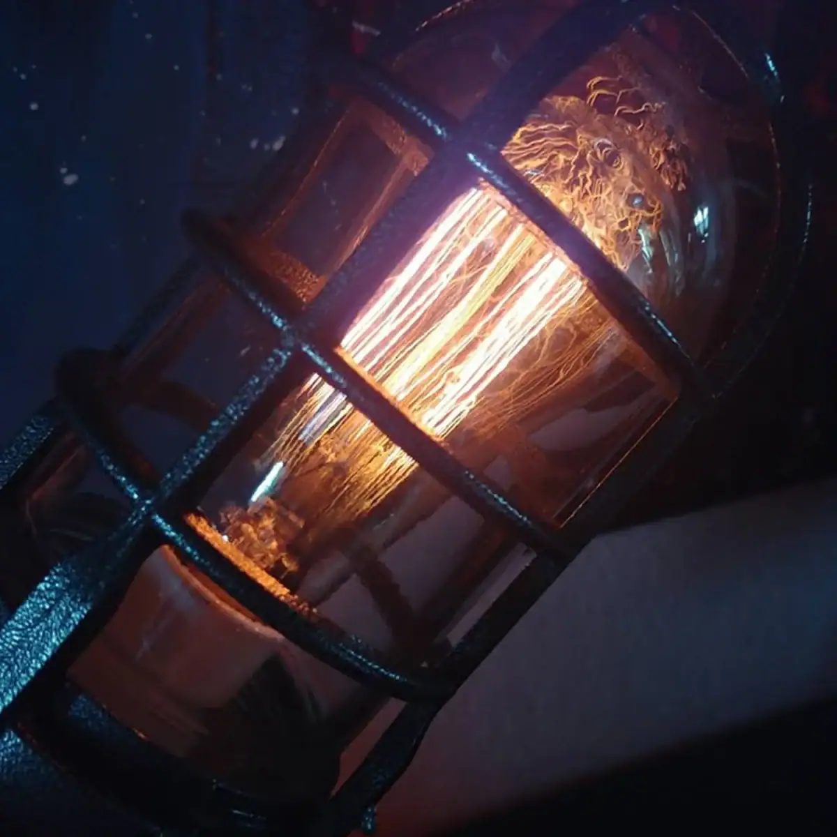 Ampoule Edison vintage dans un cadre en métal noir, illuminant une pièce avec une lumière chaude et chaleureuse.