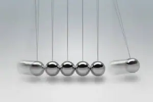 Boules de Newton en acier inoxydable suspendues, illustrant la transfert d'énergie et la conservation de la quantité de mouvement, parfaites pour la décoration scientifique.