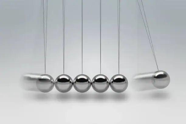 Boules de Newton en acier inoxydable suspendues, illustrant la transfert d'énergie et la conservation de la quantité de mouvement, parfaites pour la décoration scientifique.