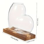 Vase en forme de cœur en verre transparent avec socle en bois, parfait pour la décoration scientifique ou romantique. Dimensions : 13 cm de haut, 17 cm de long, 5,5 cm de large.