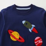 Pull enfant brodé motif fusée et planètes.