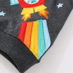 VĂȘtement pour enfant avec patch scientifique colorĂ©, motif de fusĂ©e et Ă©toiles, en tissu gris foncĂ©, idĂ©al pour une dĂ©coration ludique et Ă©ducative.