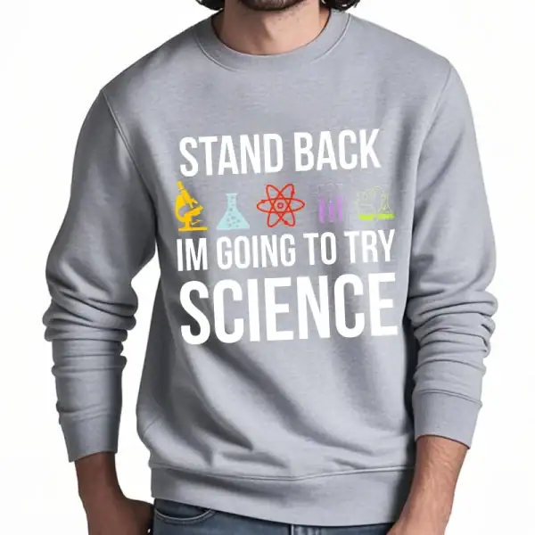Sweatshirt gris avec message humoristique "Stand back, I'm going to try science" et icônes de laboratoire colorées, parfait pour les amateurs de science et de blagues.