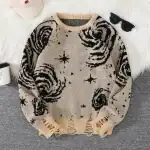 Pull en laine beige avec motifs de galaxies et étoiles noires, parfait pour un look cosy et original.
