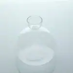 Flacon en verre transparent utilisé en laboratoire scientifique, avec un col étroit et une forme arrondie, idéal pour les expériences et la décoration.