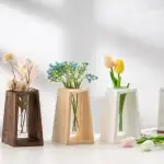 Vase en bois foncé, en céramique blanche et en céramique beige, chacun contenant des fleurs artificielles colorées, parfaits pour la décoration intérieure élégante.