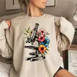 Microscope avec fleurs colorées pour décoration scientifique et botanique. Parfait pour les amateurs de sciences et de nature, cette illustration combine la recherche et la beauté naturelle.